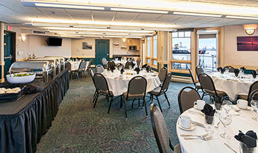 tables and chairs prepared with white table cloths in park point marina inn's meeting & banquet rooms 