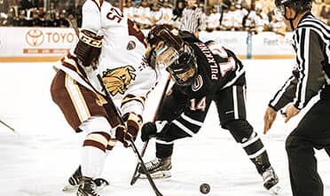 a hockey game in the Arena with two players battling for the puck