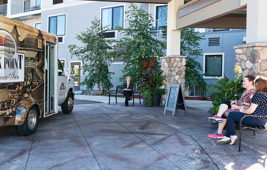 a shuttle waits outside of Park Point Marina Inn's entrance while guests wait to board