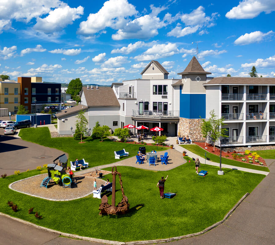 the overlook of Park Point Marina Inn taking from the sky with a group of people sitting outside