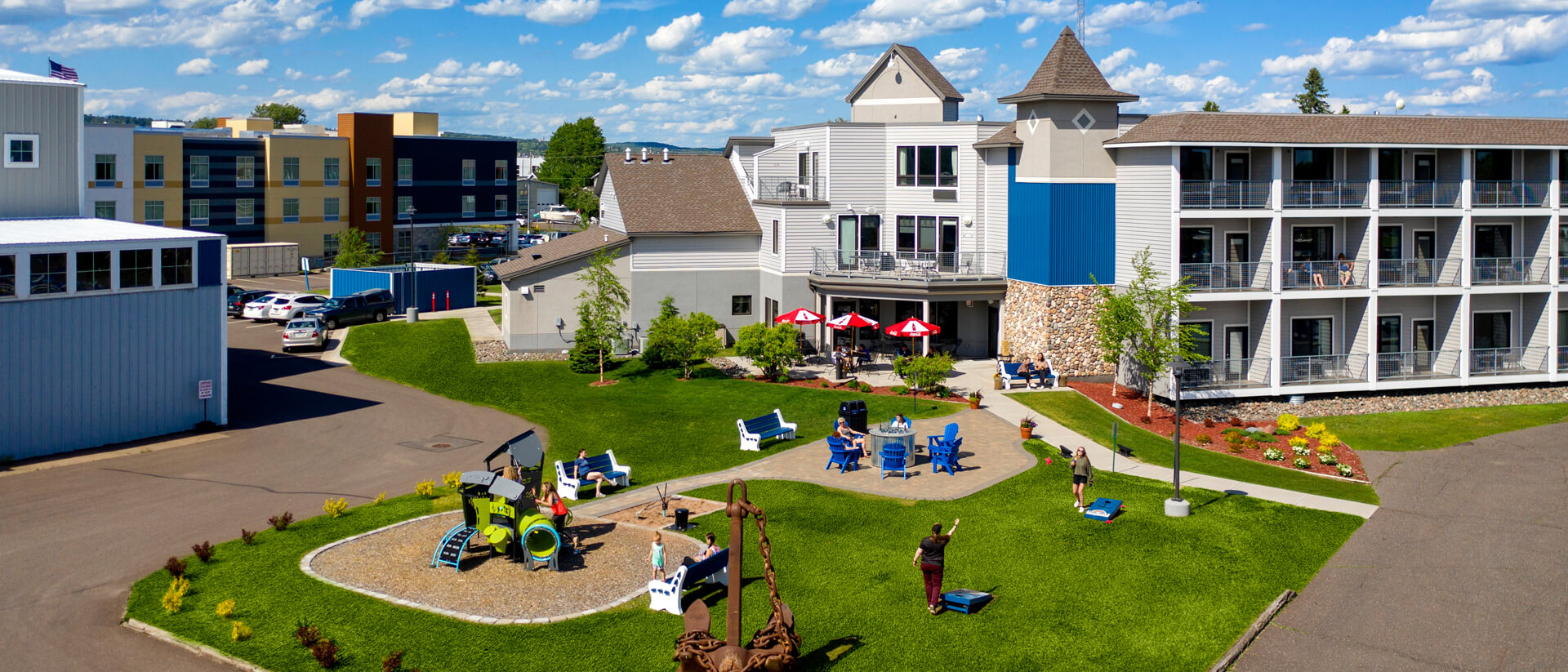 the overlook of Park Point Marina Inn taking from the sky with a group of people sitting outside